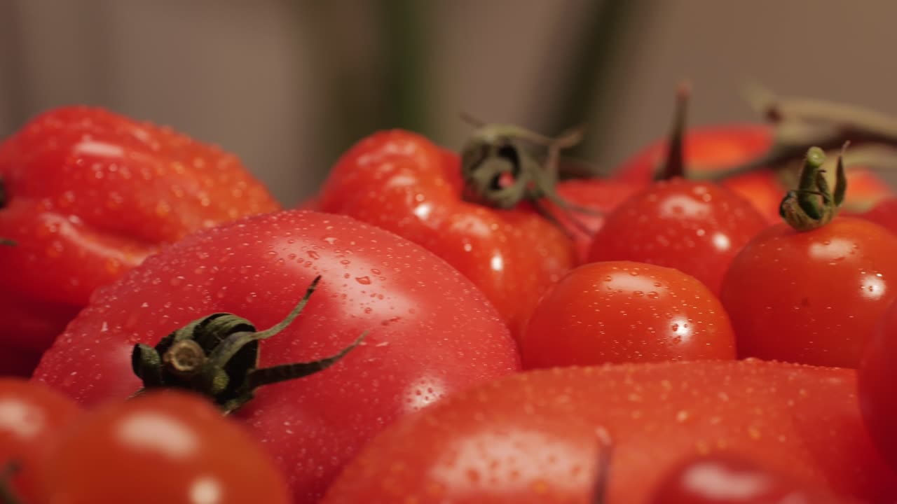 Colorful organic tomatoes. Mix tomatoes background, Several varieties of sliced tomatoes top view. Different assorted colorful tomatoes, heirloom, cherry, rose, beefsteak, cocktail, grape, purple.