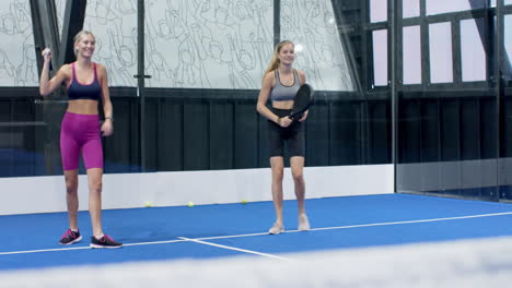 women playing padel tennis on indoor court, focusing on game strategy
