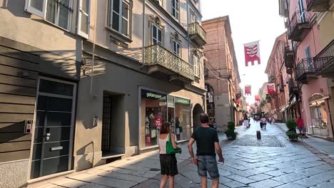 una pareja caminando junto a tiendas en piamonte, italia