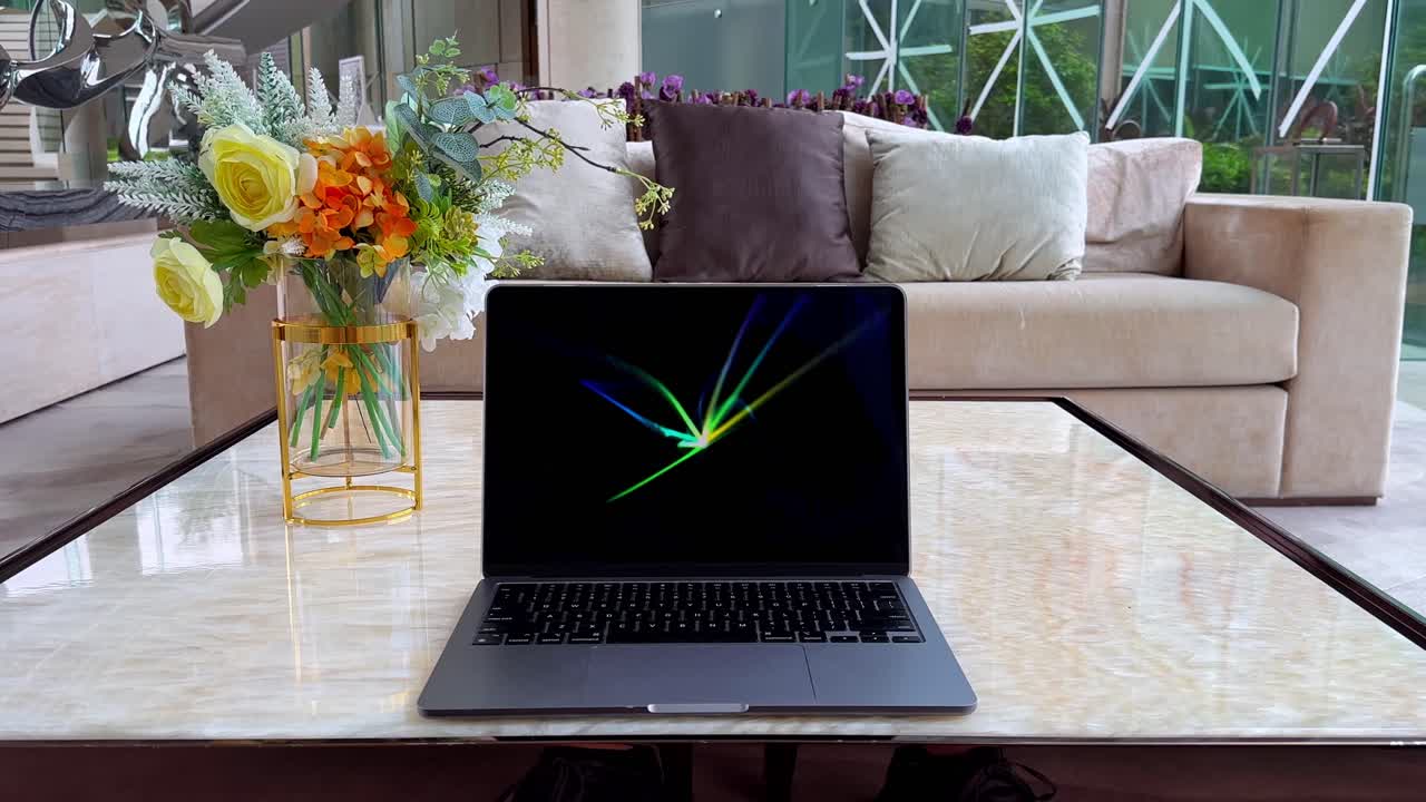 macbook en una mesa de mármol que muestra un protector de pantalla en el interior de una casa de lujo