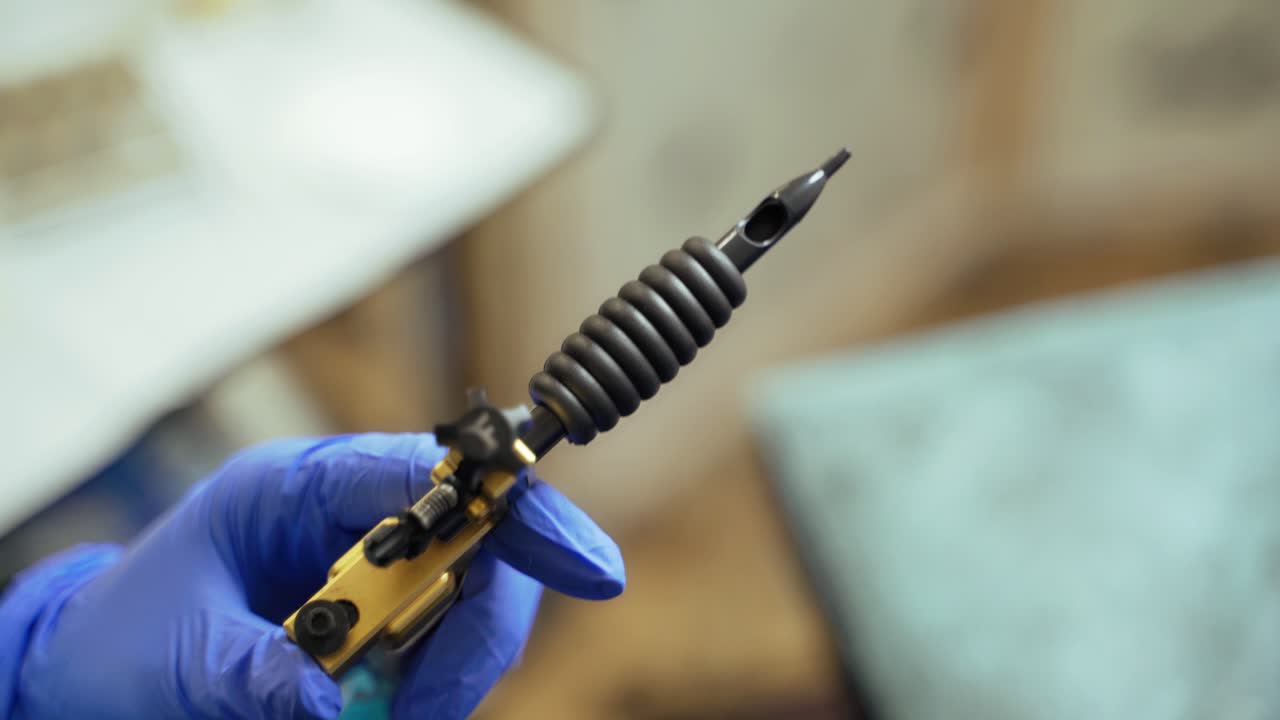 A beauty master is holding a machine for permanent make up in his hands in a beauty studio on a blurred background. Close-up