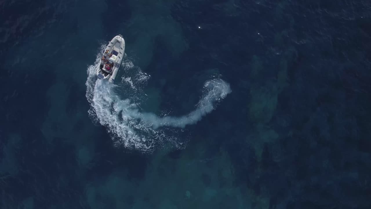 파도를 만드는 원을 그리며 움직이는 흰색 쾌속정