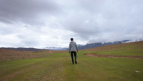 Video-of-a-young-man-standing-by-himself-in-a-calm,-natural-forest-setting,-looking-sad-and-lonely