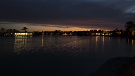 Twilight-glow-over-Nile-river-with-silhouette-of-palm-trees-and-Cairo-cityscape