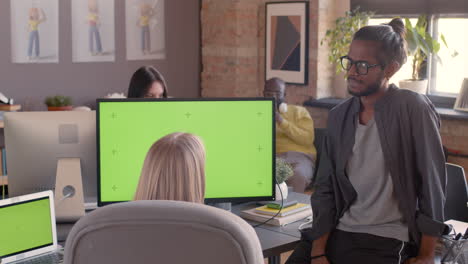 two multiethnic colleagues talking together in the office 1