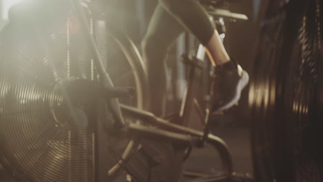woman exercising on an air bike in a gym