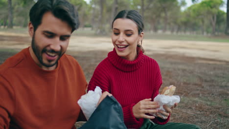 Pareja-Sonriente-Preparando-Un-Picnic-En-Una-Manta-En-El-Primer-Plano-Del-Parque.-Familia-Disfruta-El-Fin-De-Semana