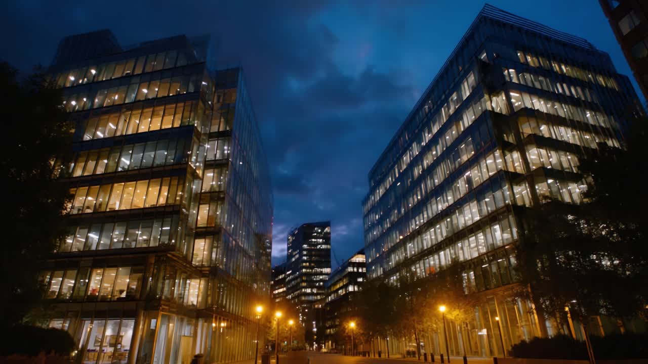 Vista noturna dramática de escritórios de vidro modernos sob um céu crepuscular, capturando a atmosfera vibrante da arquitetura urbana e da vida profissional noturna
