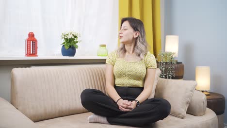 the young woman in front of the window, taking a deep breath and closing her eyes.