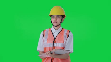 Confused-Indian-female-architect-taking-notes-in-building-Green-screen