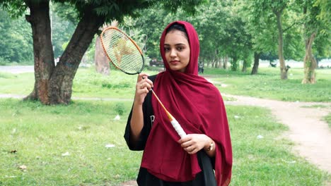 Nahaufnahme-Eines-Schönen-Afghanischen-Mädchens-Im-Hijab,-Das-Den-Badmintonschläger-Hält-Und-Lächelt-Und-In-Die-Kamera-Schaut