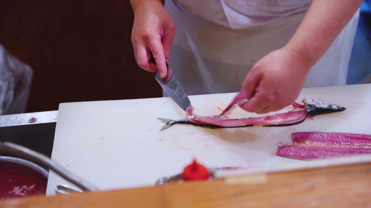Koki Sushi Menyiapkan Ikan Sama, Saury Pasifik untuk Hidangan Sashimi Omakase, Jepang.