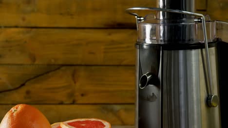 Grapefruit--Und-Saftpresse-Auf-Einem-Holztisch-4k