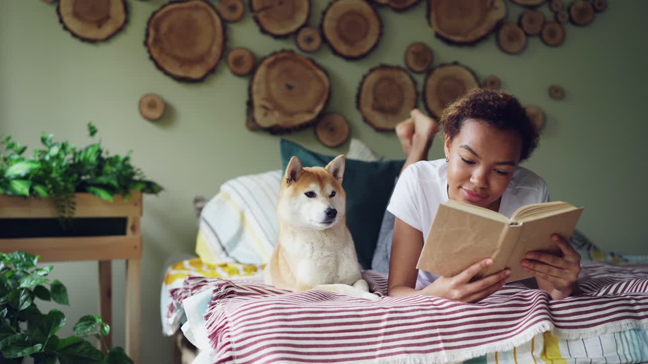 Woman Reading with Dog in Bedroom