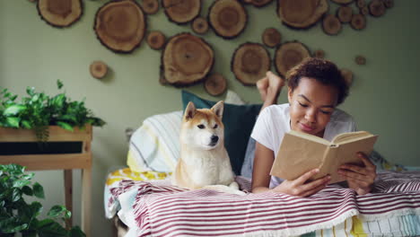 woman reading with dog in bedroom