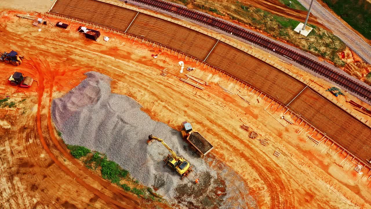 Aerial View Of Quarrying Site Near Railway Line With Excavator And Trucks For Hauling Materials