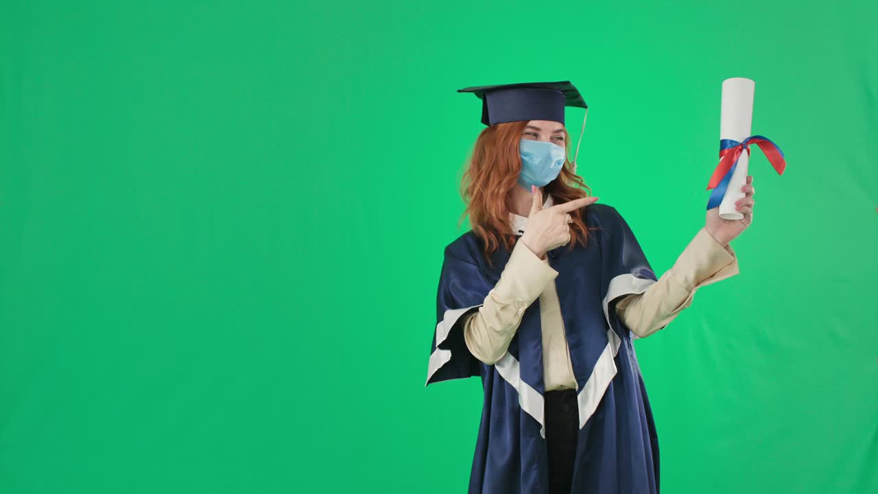 studia in quarantena, affascinante laureata con una maschera medica con il diploma in mano mostra il pollice in alto sfondo, chiave croma