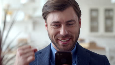 smiling business man getting good news on phone. happy guy with mobile phone.