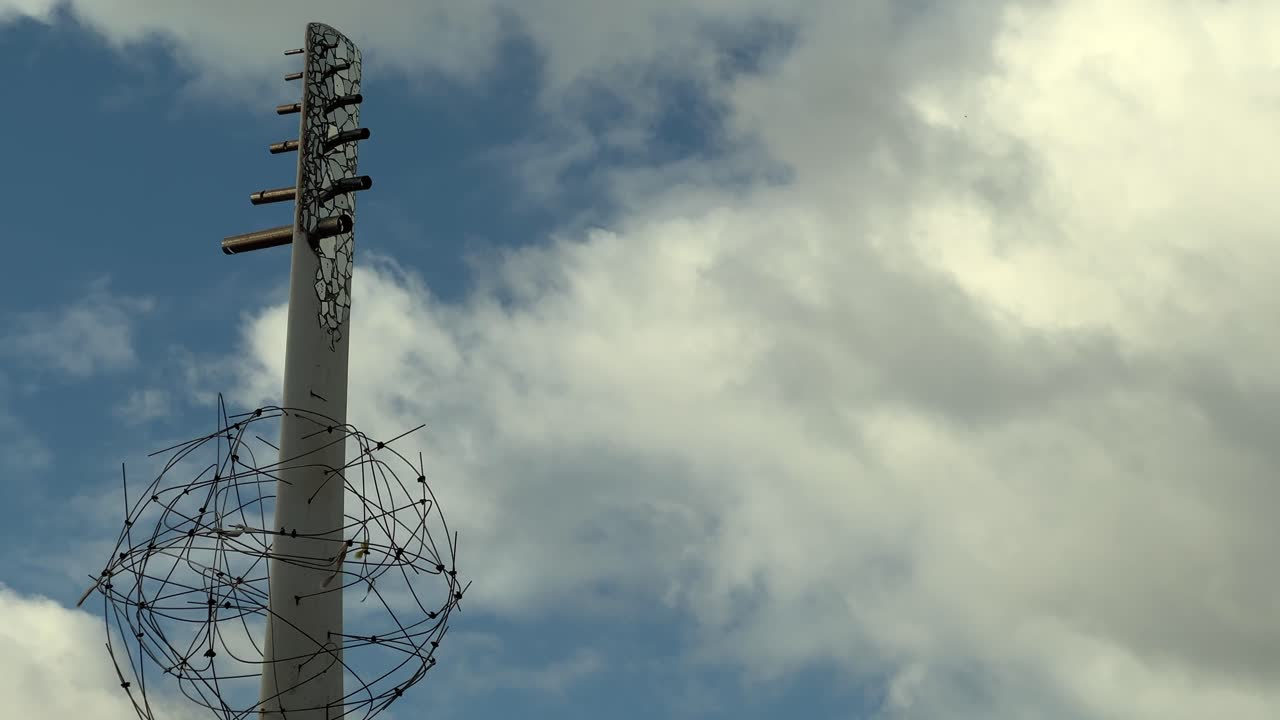 exhibición artística que realza la costa española, enfatizando la creatividad y promoviendo el turismo, enmarcada por un cielo nublado