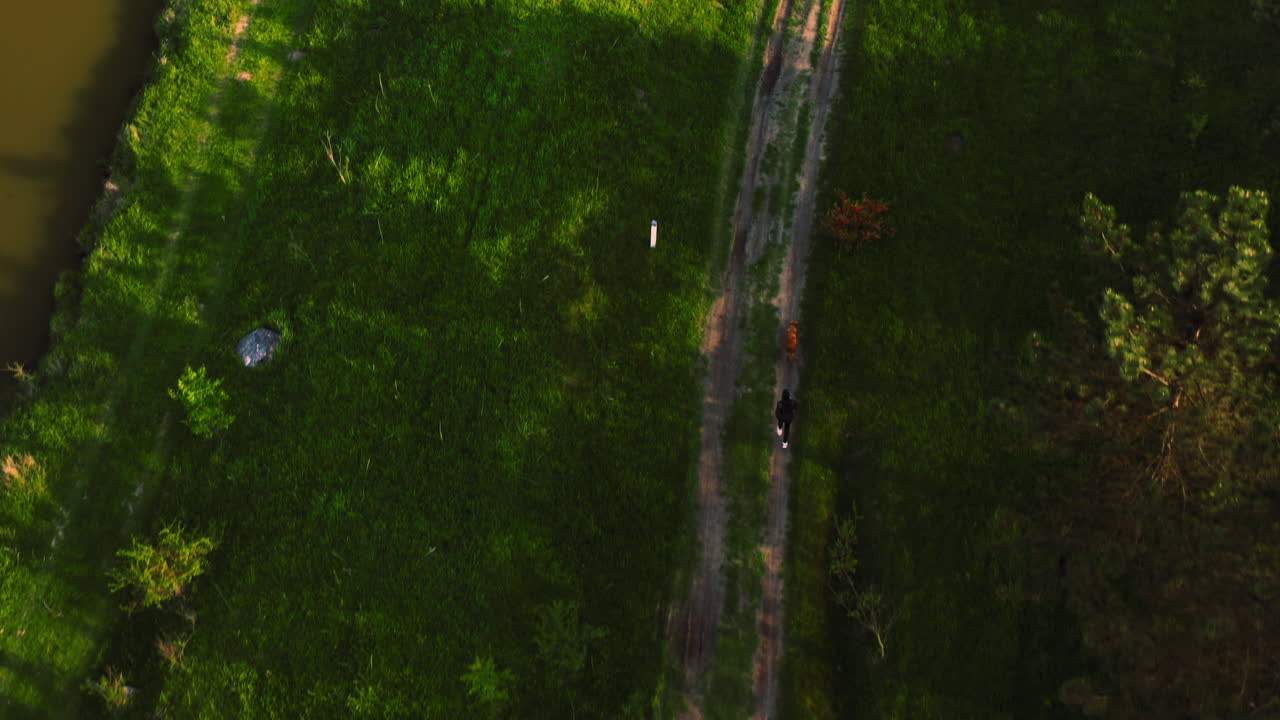 mujer corriendo con su perro golden retriever vista de arriba hacia abajo tiro de seguimiento