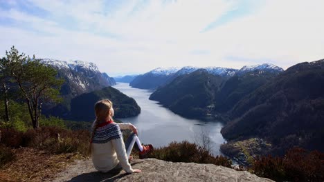 young woman arrives at veafjord viewpoint, sits down to enjoy view and stretch legs, norway