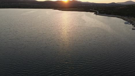 aerial sunrise over mountain lake: tranquil morning light sun reflecting the lake