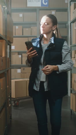 warehouse worker using smartphone for inventory management