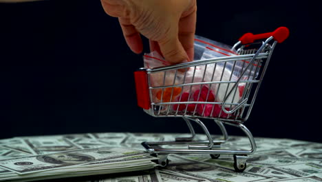 Hand-put-dollar-and-pickup-medicine-in-a-shopping-cart