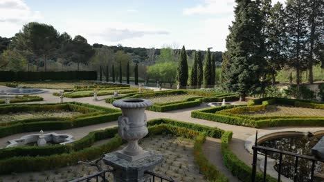 Una-Panorámica-De-Un-Jardín-Barroco-A-La-Derecha,-Con-Una-Maceta-Decorativa-En-Primer-Plano