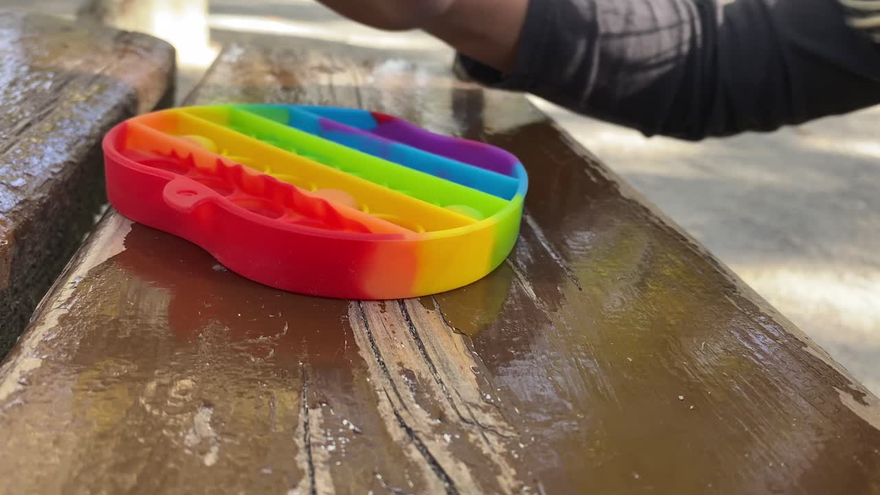 사과 모양의 팝잇을 가지고 노는 소녀의 손