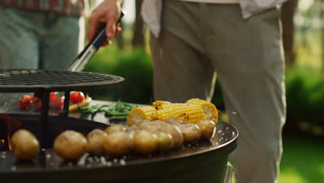 las manos del hombre vertiendo sal en la barbacoa