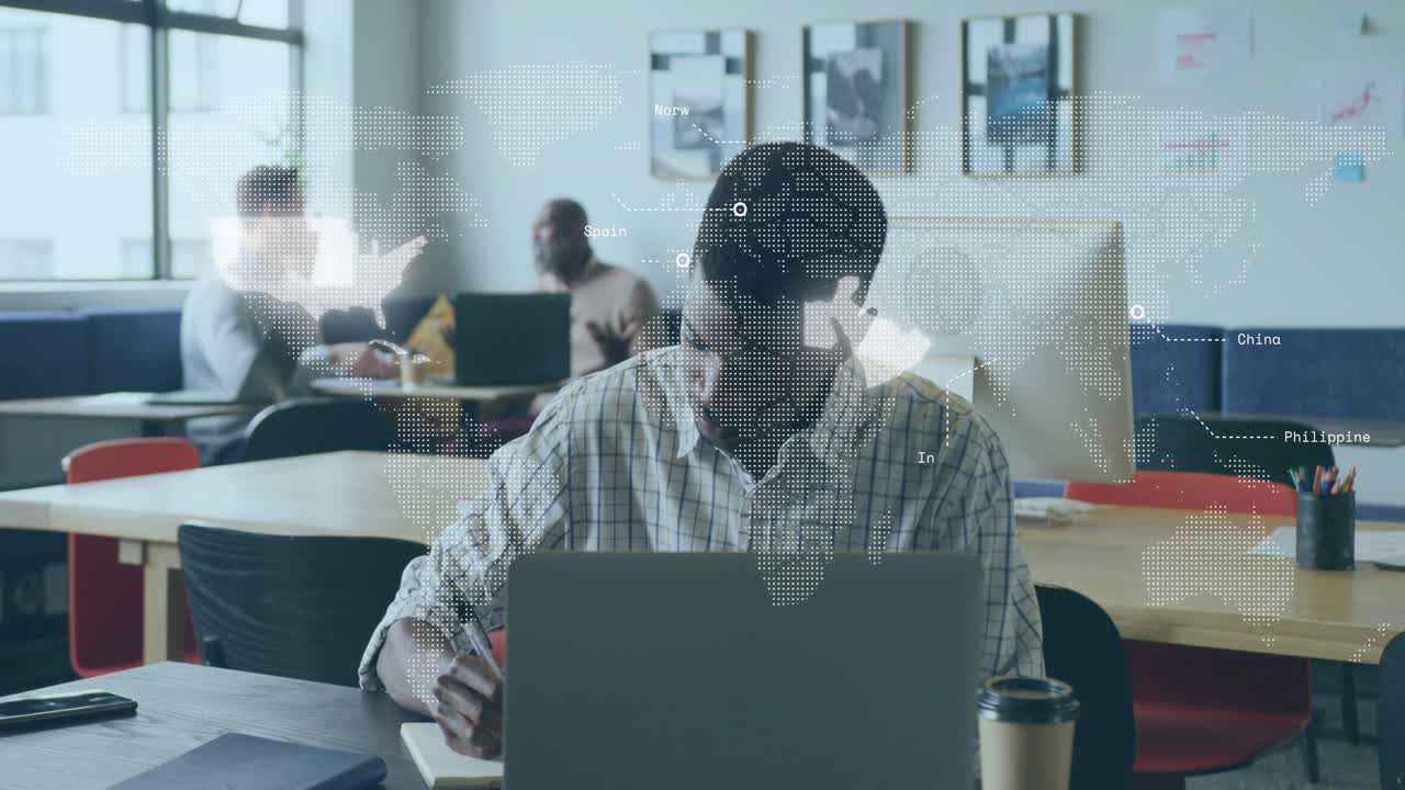 Mature adult male jotting notes at coworking desk and activating map overlay for business analysis