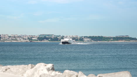 piran, slowenien - jul 03 2023: ein weißer katamaran fährt mitten im meer mit der kroatischen küste im hintergrund