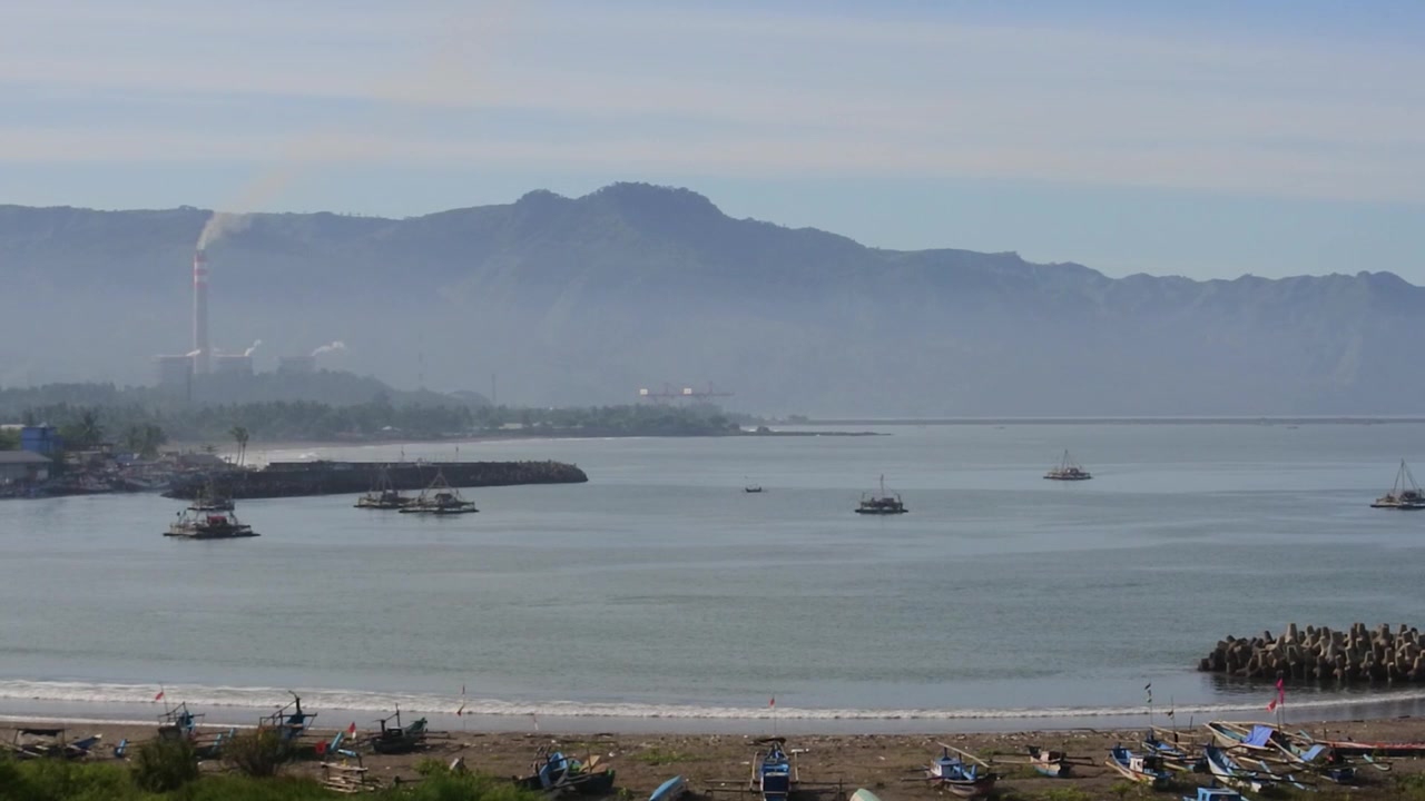 Arka planda bir buhar enerji santrali bacası ile Pelabuhan Ratu plajı, Sukabumi, Batı Cava'nın güzelliği