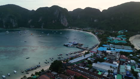 Koh-Phi-Phi-harbor-with-boats-and-yachts-docked-at-early-morning-dawn,-blue-hour