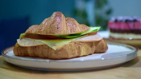 a close-up of a delicious croissant sandwich on a plate