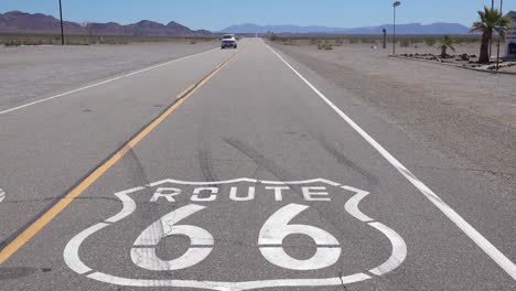 establishing shot of a lonely desert highway in arizona with route 66 painted on the pavement 1