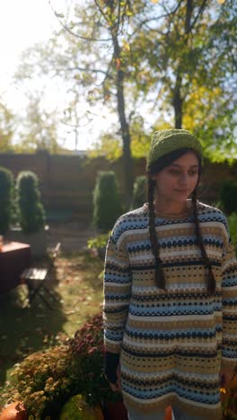 mujer en el jardín de otoño con calabazas
