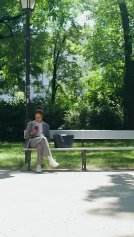 businesswoman using smartphone in a park