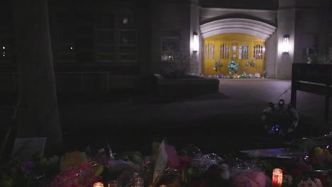 berkey hall on the campus of michigan state university, the site of a mass shooting in february of 2023 at night with flower memorial panning left to right
