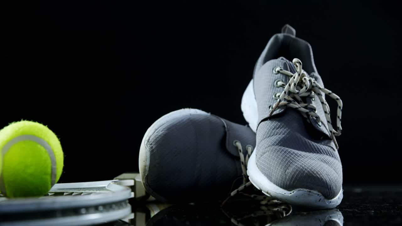 pelotas de tenis, raqueta y calzado deportivo en el estudio 4k