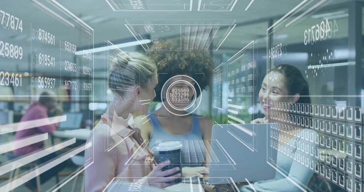 Three women collaborating on laptop in office as data HUD activating streaming analytics for review