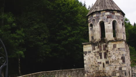 well-preserved stone bell tower of mtsvane monastery below cloudy sky