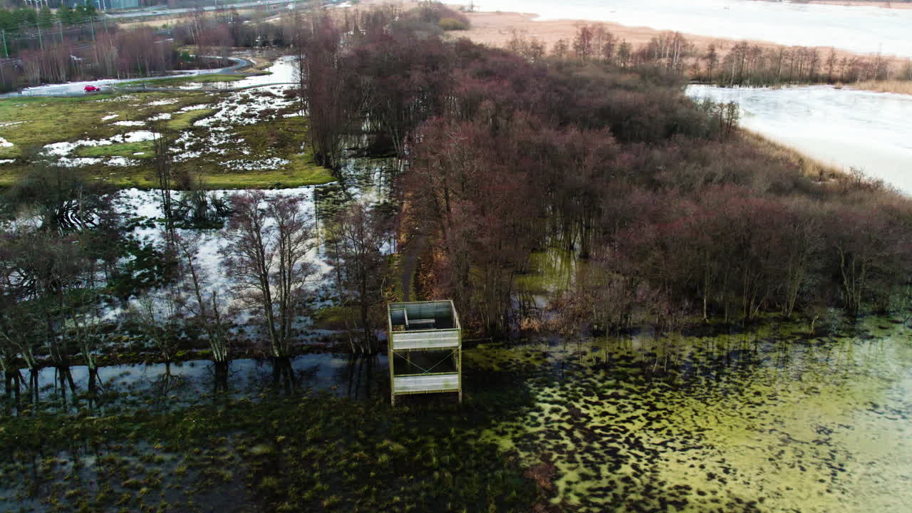torre de observación de aves inundada en el oeste de suecia al anochecer, vista aérea