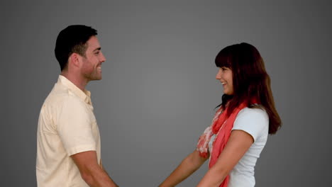 young couple cuddling on grey background