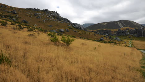 toma panorámica del campo de hierba amarilla y las famosas montañas de la colina del castillo en el fondo con un espectacular paisaje nublado oscuro en el cielo