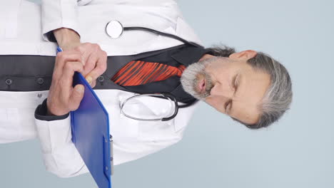 el video vertical del viejo médico examinando el papeleo es reflexivo.
