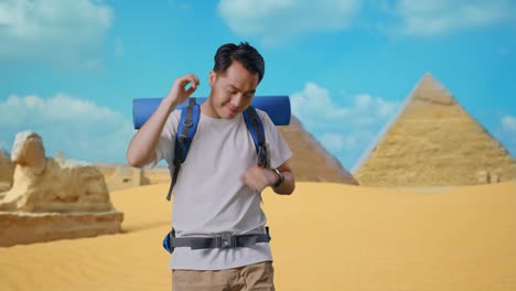 asian male hiker with mountaineering backpack enjoy dancing while traveling in pyramid of giza