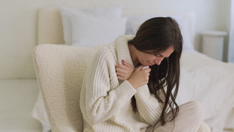 sick woman coughing sitting on chair in bedroom at home 1