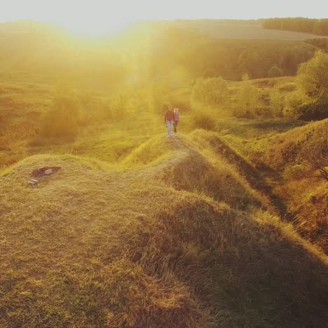 young couple walking toward sunset